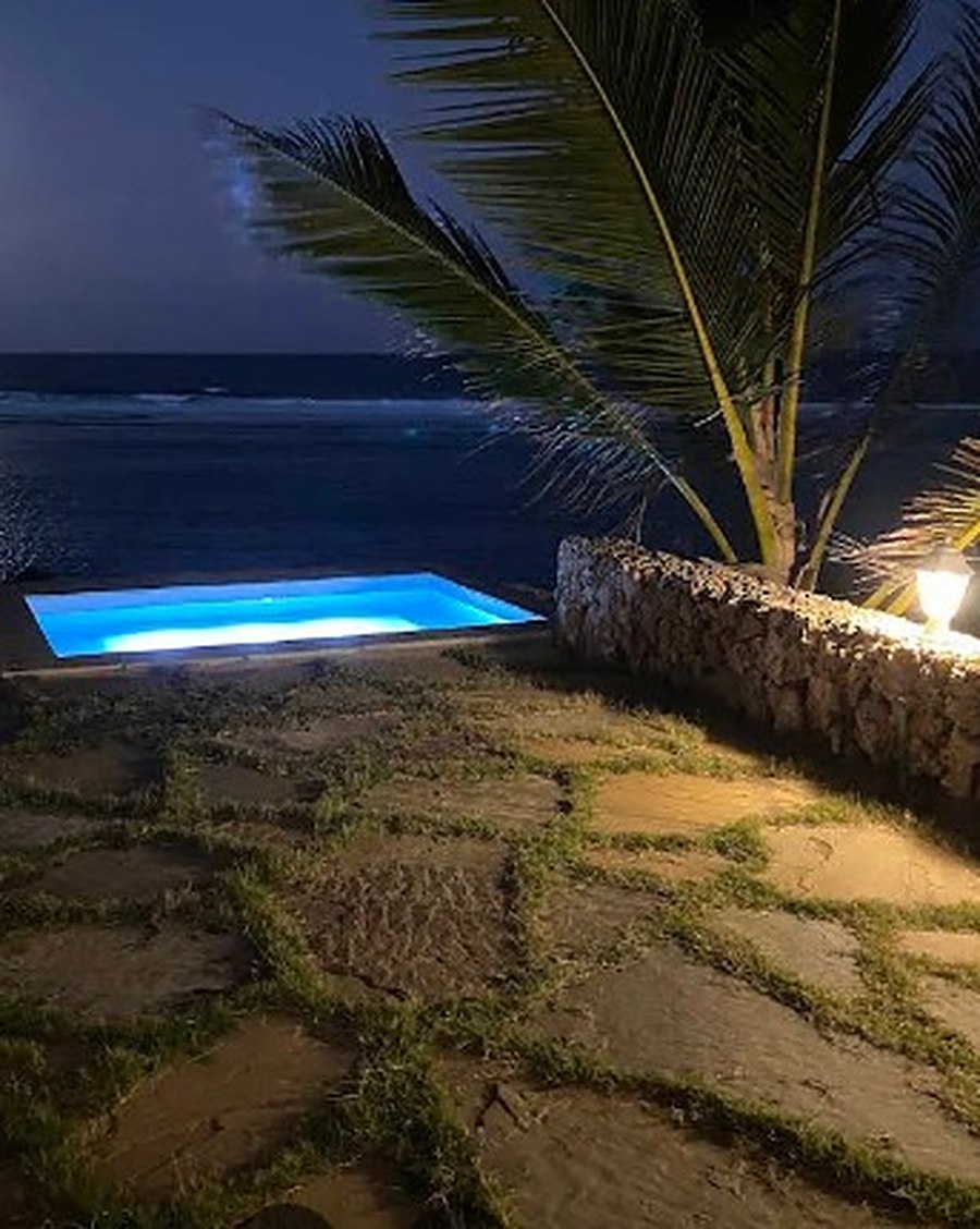 Private plunge pool lit up at night under a full moon